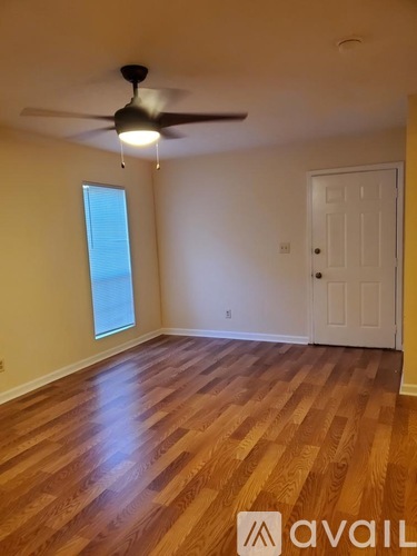 A room with wooden flooring and a ceiling fan.