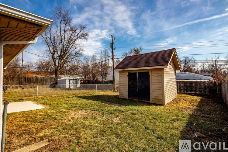 A small shed sits in a grassy backyard.