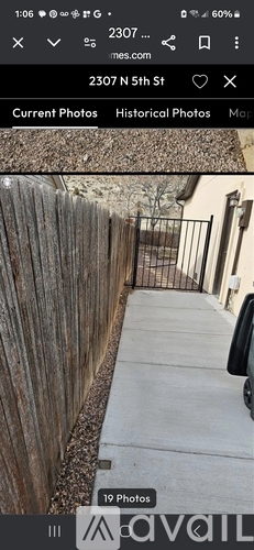 A wooden fence runs along the side of a sidewalk.