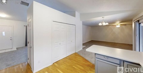 A kitchen with white cabinets and a wooden floor.