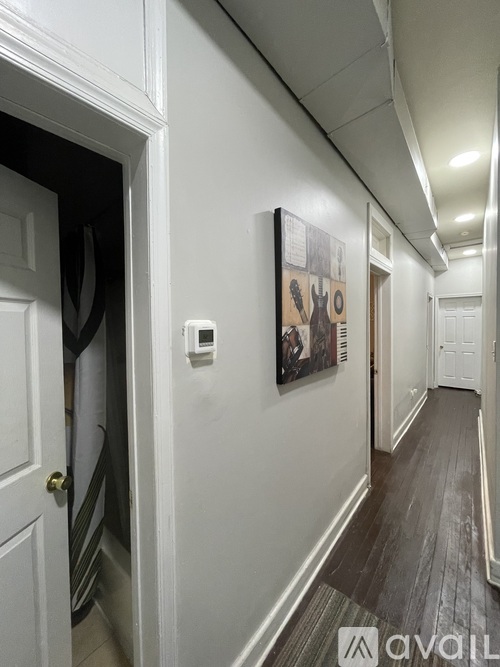A hallway with a guitar picture on the wall.