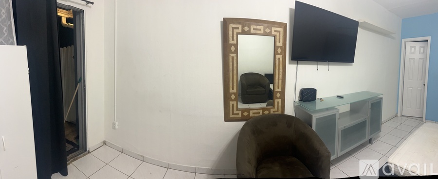 A room with a mirror and a TV on the wall.