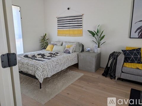 A bedroom with a bed, a couch, and a rug.
