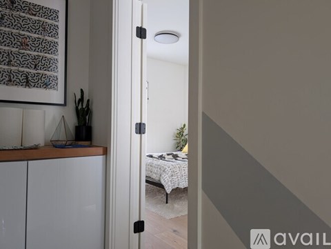 A room with a bed and a cabinet is visible through an open door.
