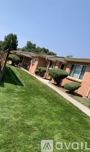 A row of houses with green lawns in front.