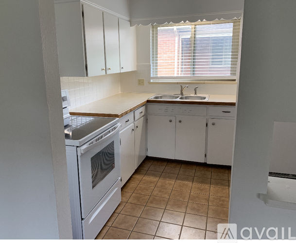 A kitchen with white cabinets and a stainless steel oven.