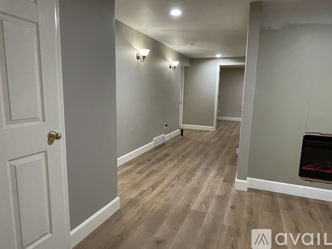 A hallway with wood flooring and white walls.
