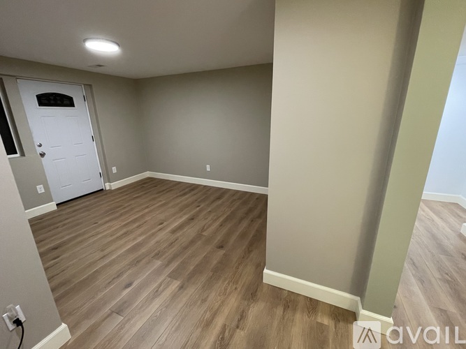 A room with wooden flooring and a white door.