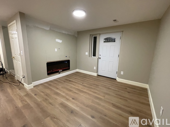 A room with a fireplace and wooden flooring.