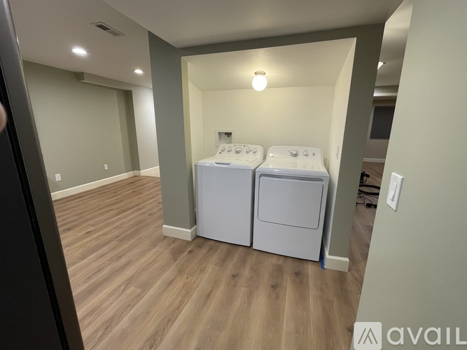 A laundry room with two washing machines and a light on the wall.