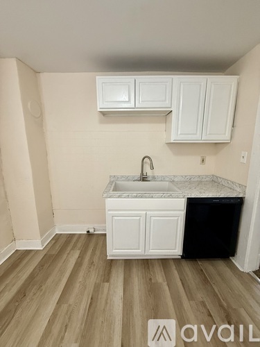 A kitchen with white cabinets and a marble countertop.
