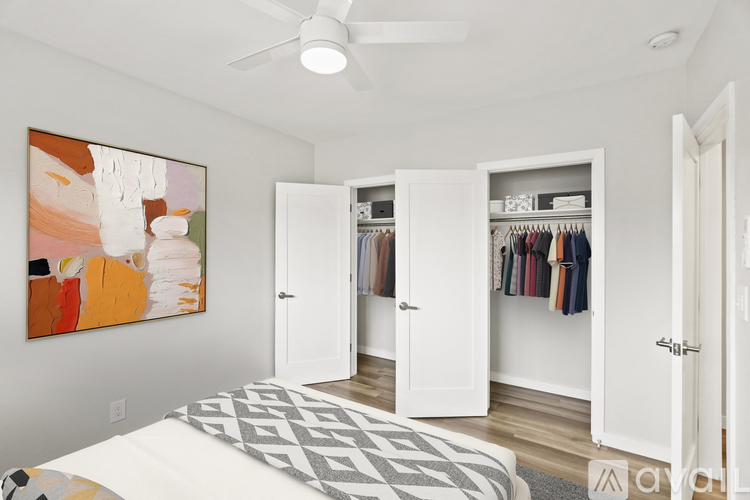 A bedroom with a large bed and a painting on the wall.