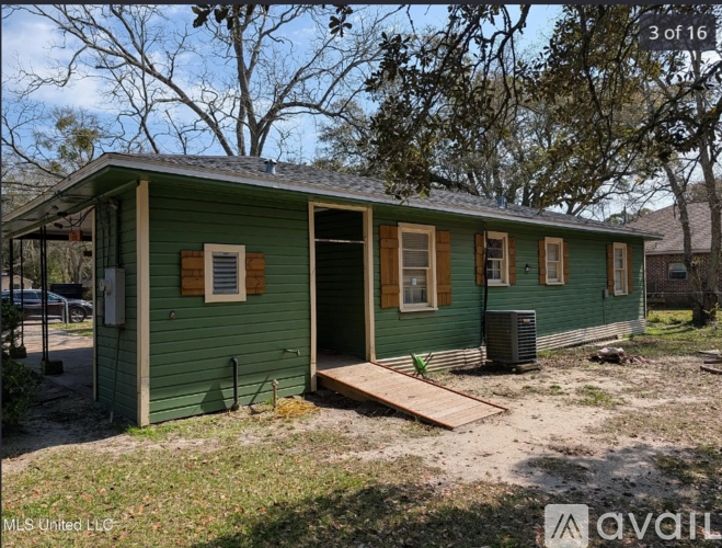 A green house with a porch and a sign that says "3 of 16".