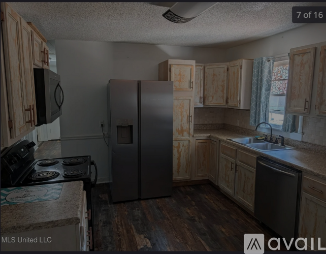 A kitchen with a stove, refrigerator, and cabinets.