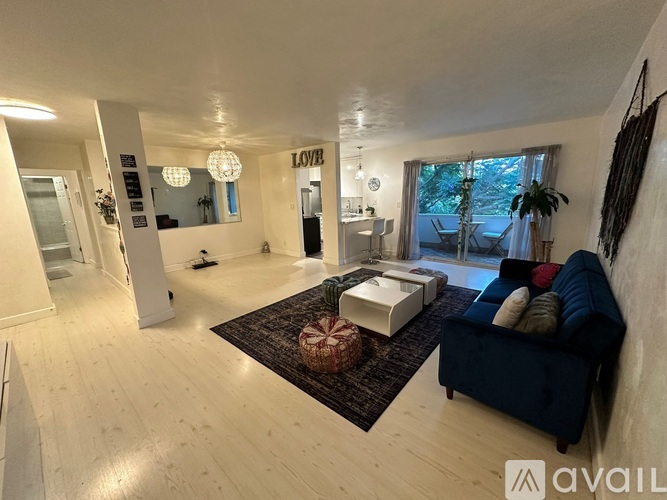 A living room with a couch, a rug, and a large window.