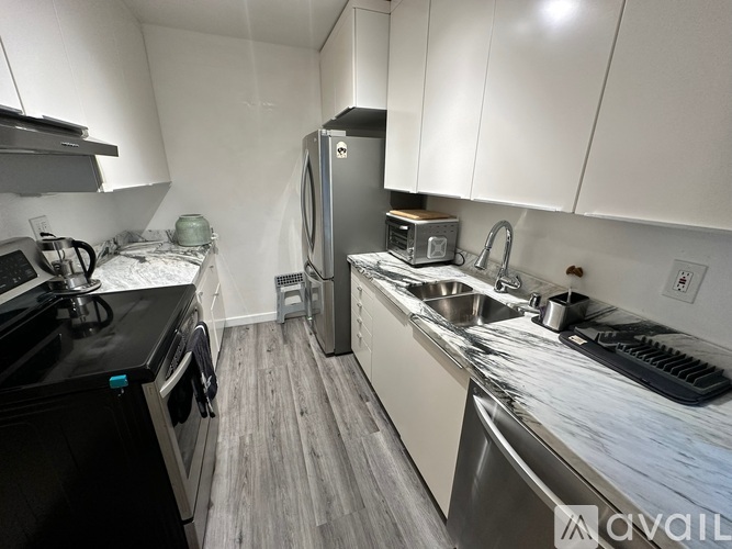 A kitchen with a black stove top oven and a silver refrigerator.