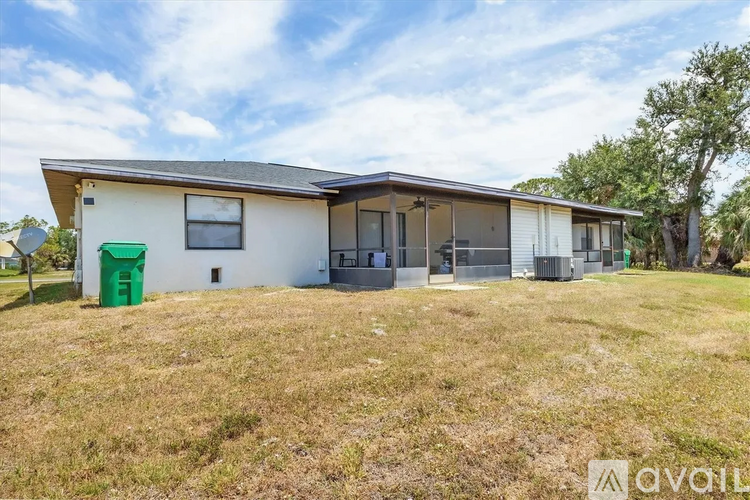 A house with a green trash bin in front of it.