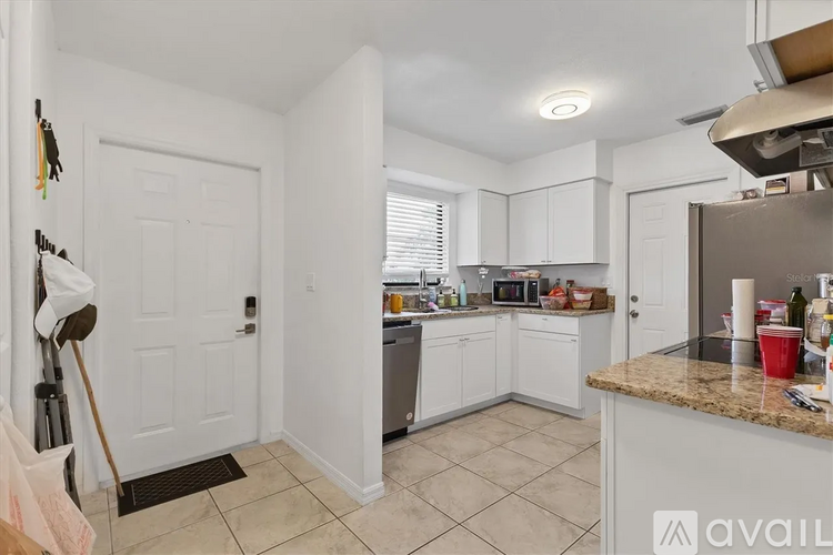 A kitchen with white cabinets and a granite countertop.