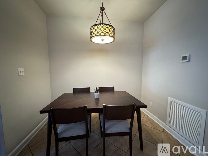 A dining room with a wooden table and chairs.