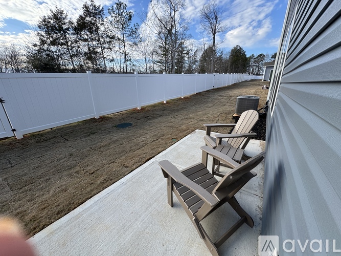 A white fence runs along the side of a building.