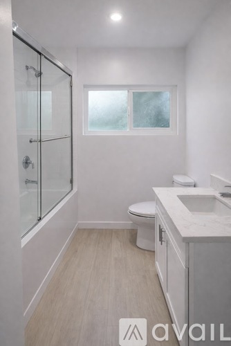 A bathroom with a toilet, sink, and shower.