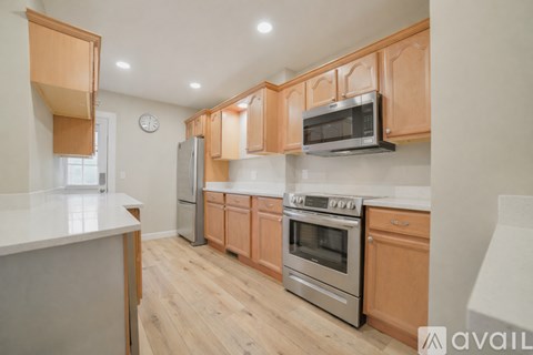 A kitchen with wooden cabinets and stainless steel appliances.