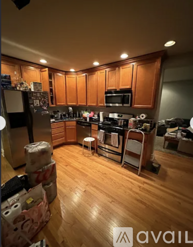 A kitchen with wooden cabinets and a black fridge.