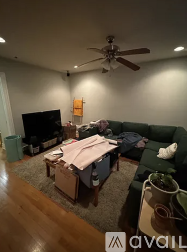 A living room with a green couch and a television.