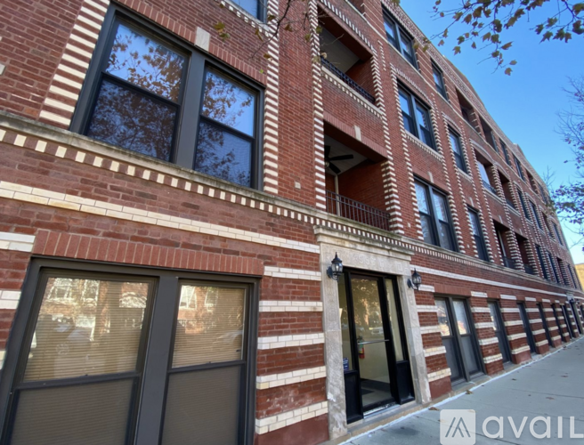 A red brick building with a row of windows on the ground floor.