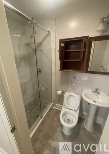A bathroom with a toilet, sink, and shower.