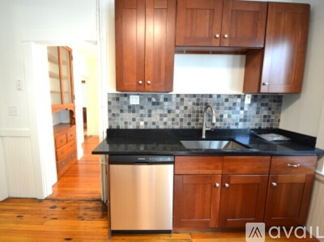 A kitchen with wooden cabinets and a black counter top.