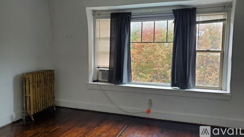 A room with a window and a radiator on the floor.