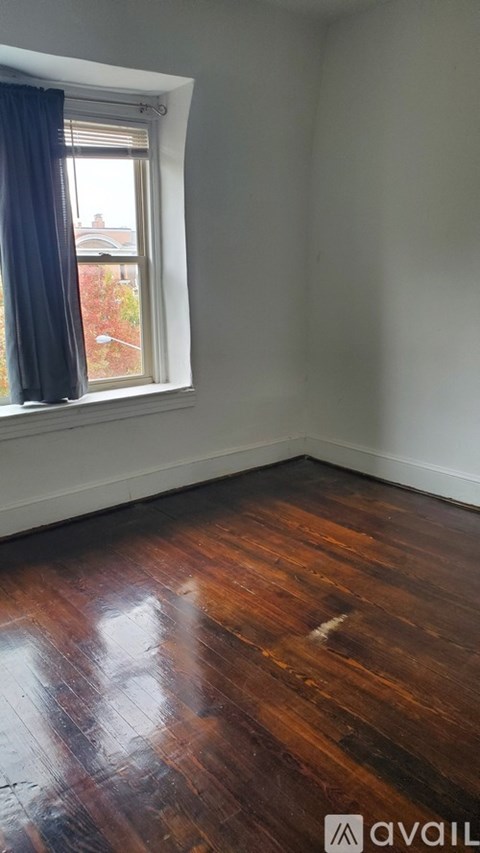 A room with a window and wooden floors.
