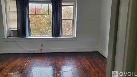 A room with a window and wooden floor.