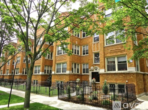 A brick building with a black fence in front.