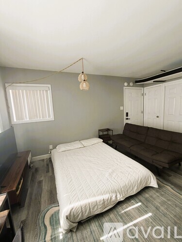 A bedroom with a bed, couch, and television.