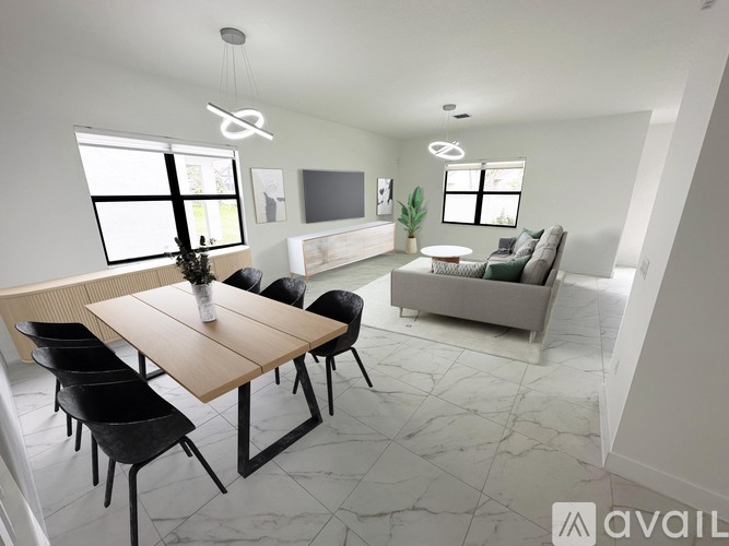 A modern living room with a wooden dining table and black chairs.