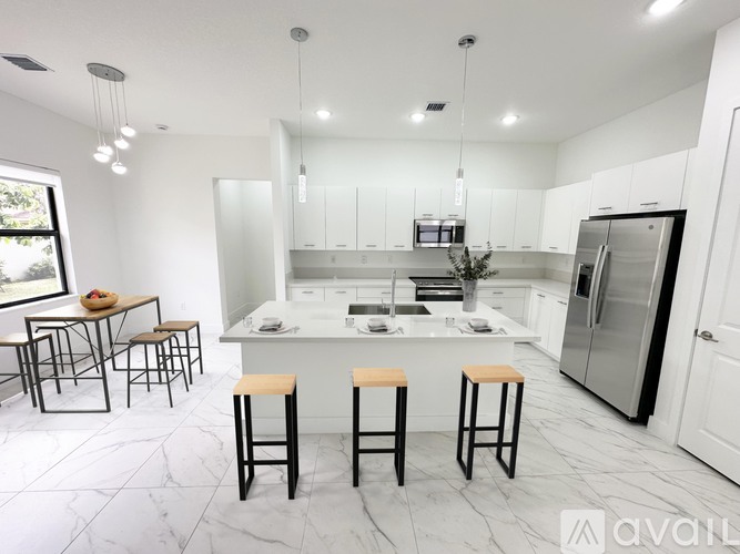 A modern kitchen with a marble floor and stainless steel appliances.