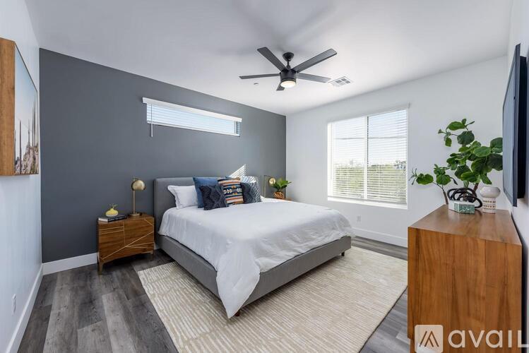 A bedroom with a bed, nightstand, and a ceiling fan.
