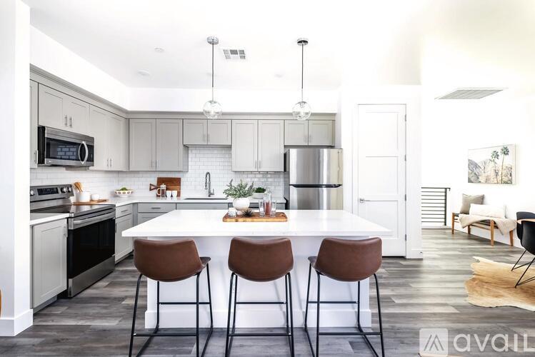 A kitchen with a white table and brown chairs.