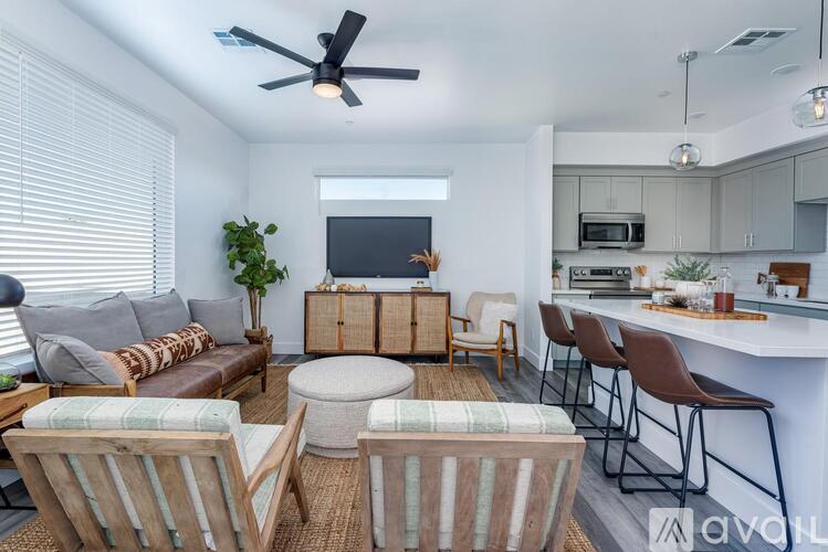 A living room with a couch, chairs, and a television.