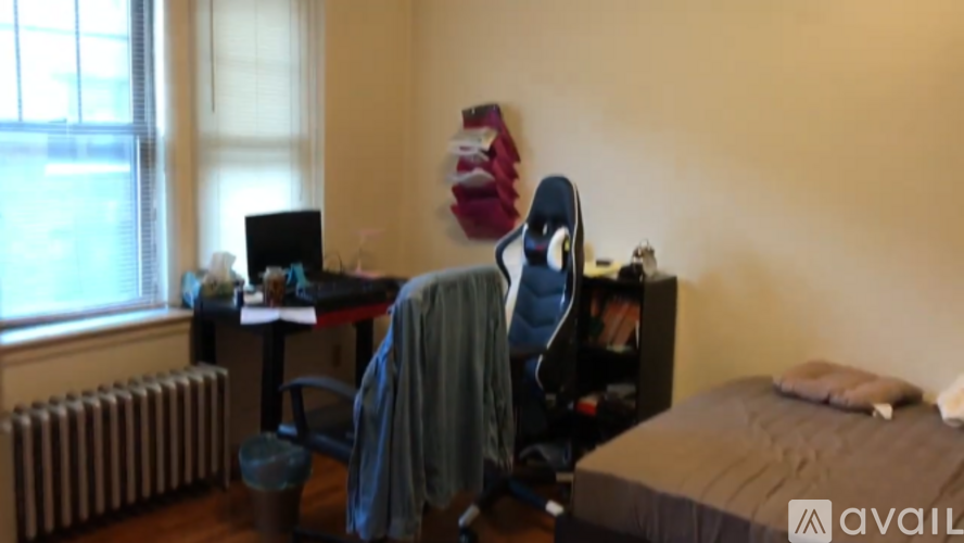 A room with a bed, desk, and chair.