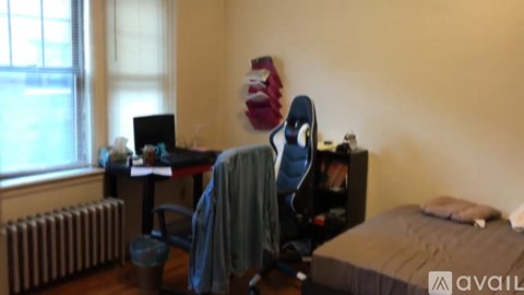 A room with a bed, desk, and chair.