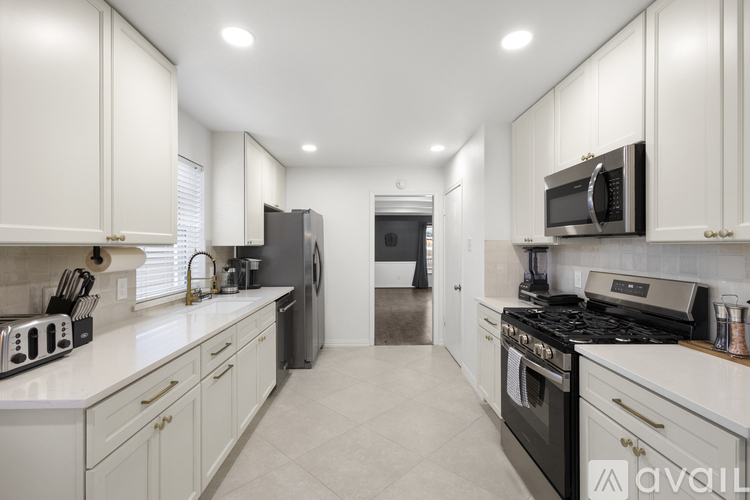 A kitchen with white cabinets and appliances.