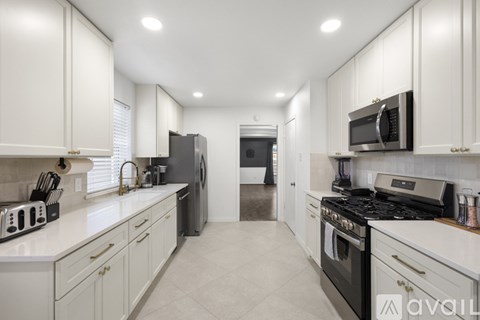 A kitchen with white cabinets and appliances.
