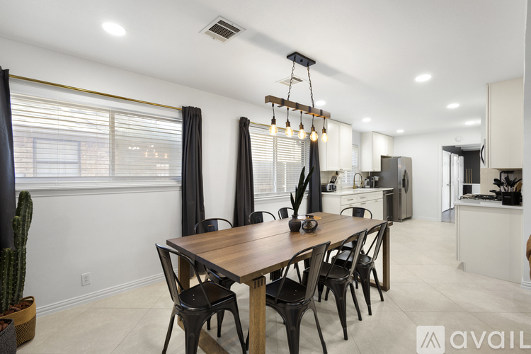 A modern dining room with a wooden table and chairs.