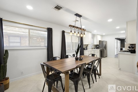 A modern dining room with a wooden table and chairs.