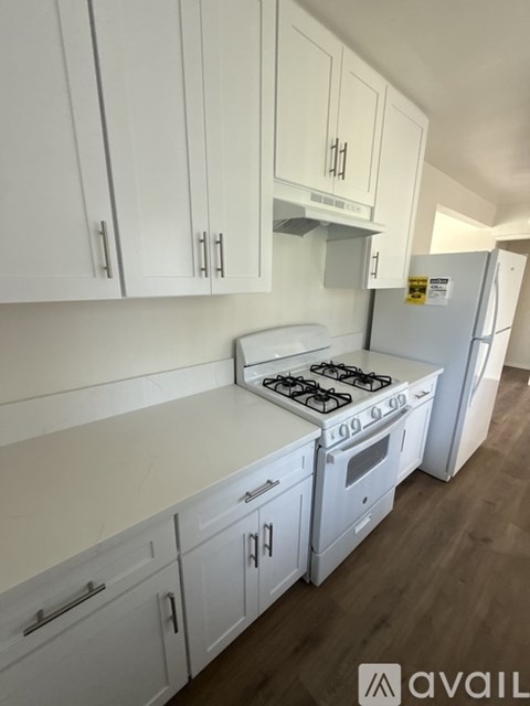 A kitchen with white cabinets and a stove top oven.