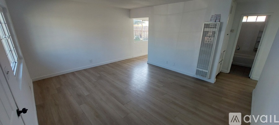 A room with wooden flooring and a window.