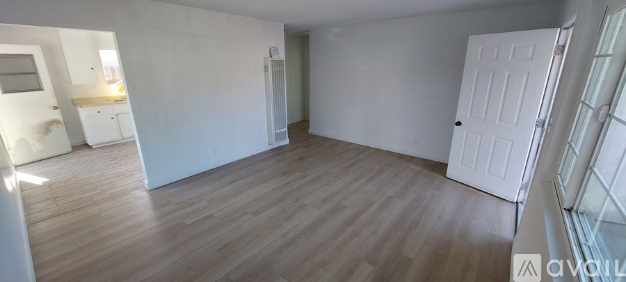A room with wooden flooring and white walls.